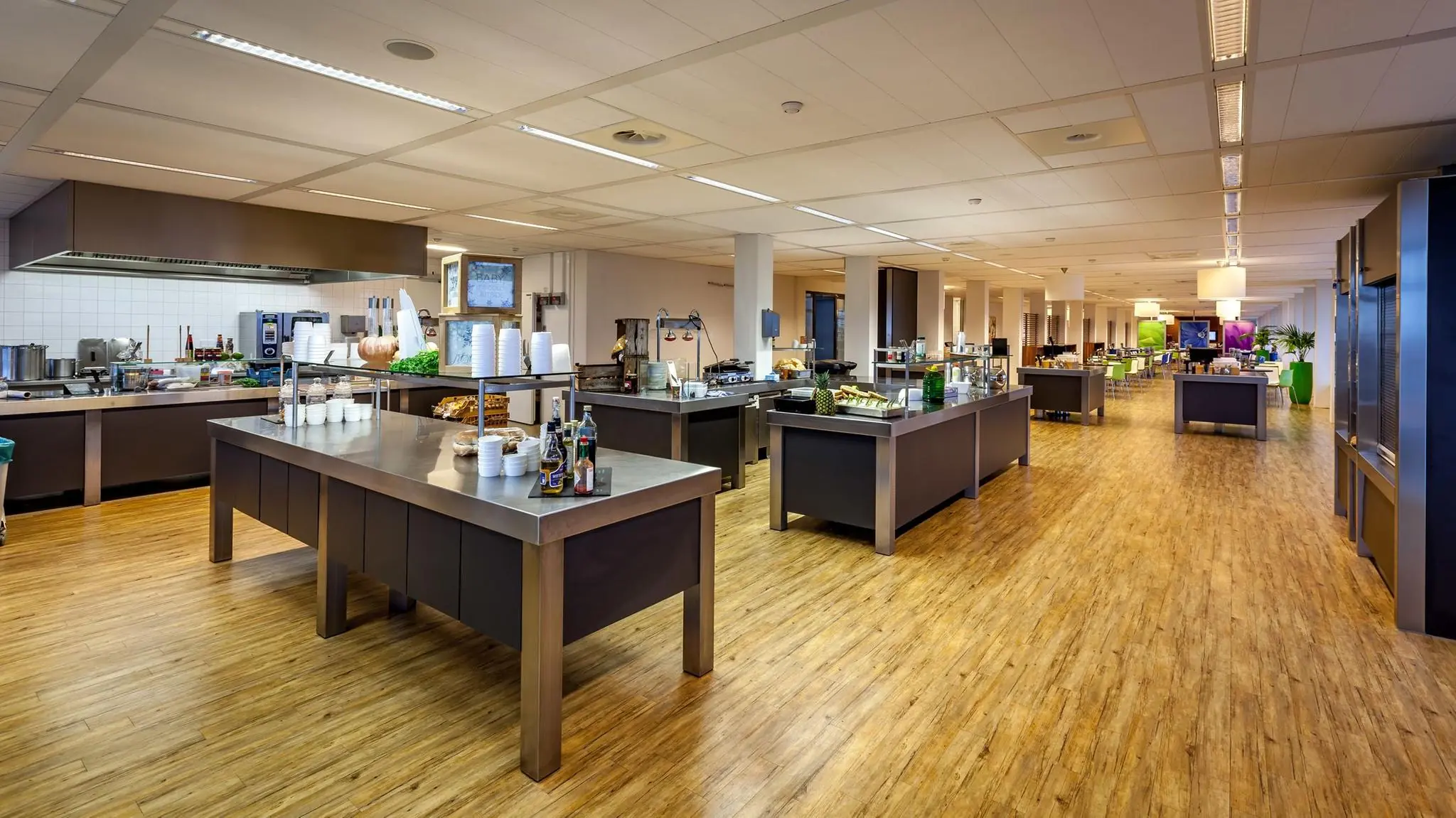 Ruime, moderne bedrijfskantine aan de Prinses Beatrixlaan met diverse uitgifte-eilanden en zitgedeelte op de achtergrond.